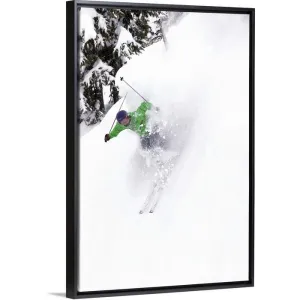 "A free skier skis down a steep hill near trees, kicking up snow." Black Float Frame Canvas Art