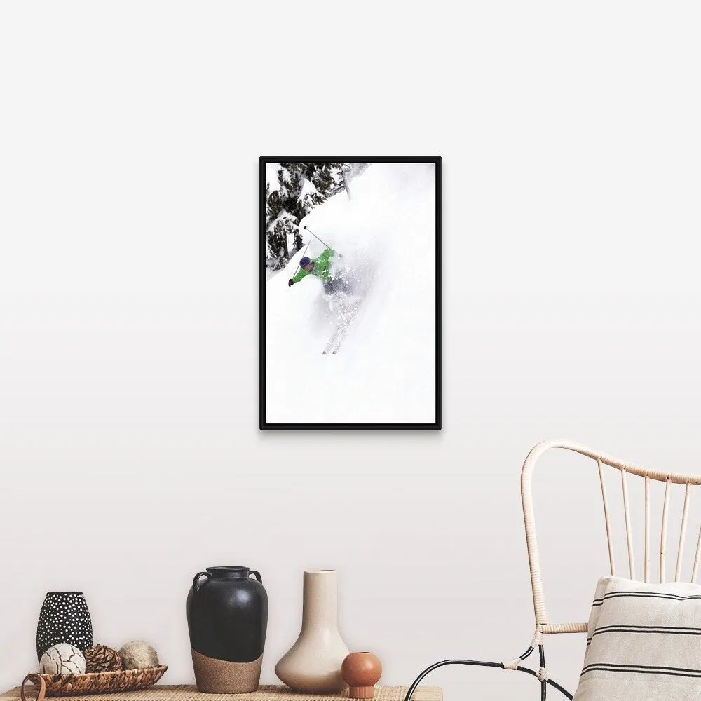 "A free skier skis down a steep hill near trees, kicking up snow." Black Float Frame Canvas Art