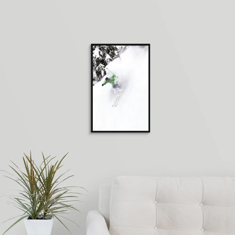 "A free skier skis down a steep hill near trees, kicking up snow." Black Float Frame Canvas Art